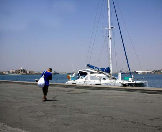 23 Chris lugs the laundry across the tarmac to Pacific Bliss